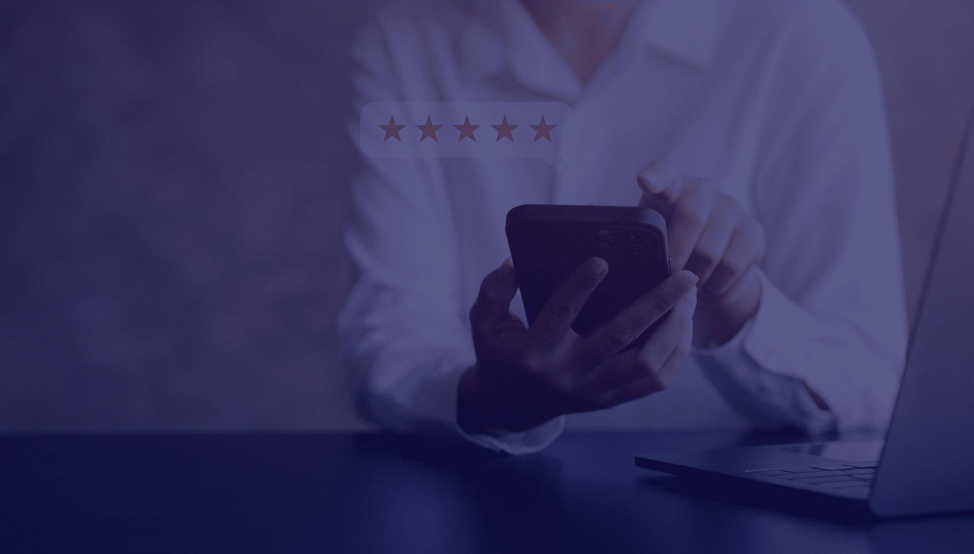 Customer Review A person in a white shirt uses a smartphone at a desk with a laptop, highlighted by a five-star rating floating above, suggesting satisfaction.